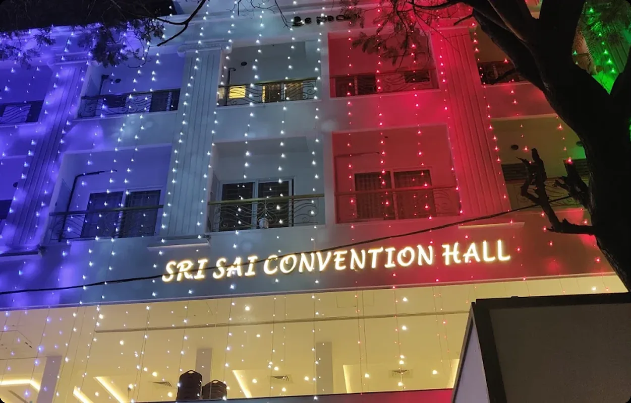 The facade in coloured lights, hall signage above the entrance