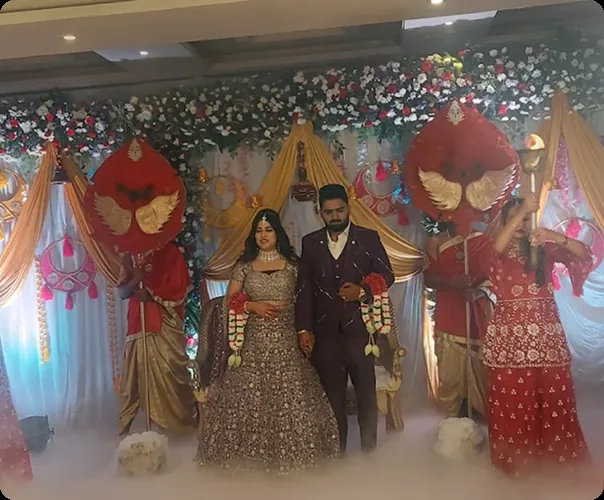 A couple on stage in front of the floral backdrop