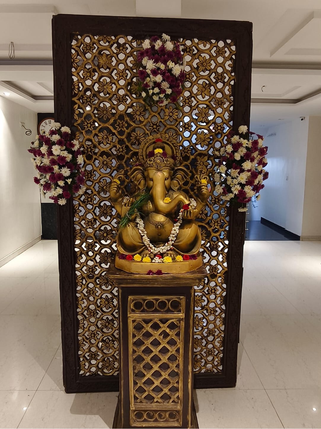 A Ganesha shrine on a carved backdrop in the foyer at Sri Sai Convention Hall, Jayanagar 9th Block