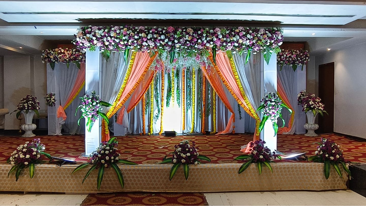 A wedding mandap in yellow and green drapes on the raised stage, Sri Sai Convention Hall, Jayanagar